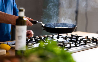 Frying a fish fillet in a hot, smoking cast iron pan.