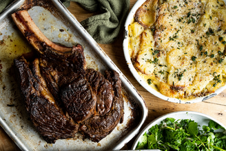 A whole, cooked, Côte De Bœuf with Dauphinoise Potatoes and greens.