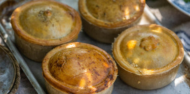 Four cooked pies on a tray