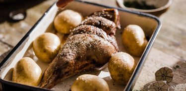 A cooked Grass Fed Lamb Roasting Joint on an oven tray.