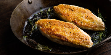 Properly free range chicken breasts cooking in a pan