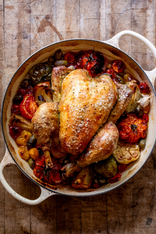 A whole, cooked. 100% pastured properly free range chicken on a bed of tomatoes, garlic, onion, and seasonings.