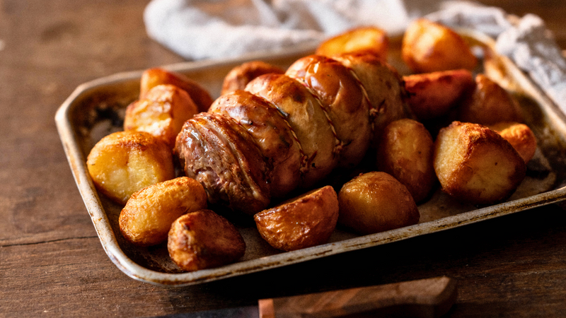 A cooked properly free range boneless turkey leg with roast potatoes