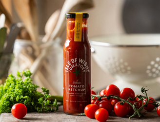 A bottle of Isle of Wight, Classic Tomato Ketchup with tomatoes and parsley.