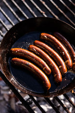 Fowlescombe Rare and Pasture Ltd Organic Grass Fed Beef Curry Frankfurters cooking in a pan.