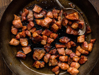 A plate of raw, Traditionally Cured Unsmoked Bacon Lardons.