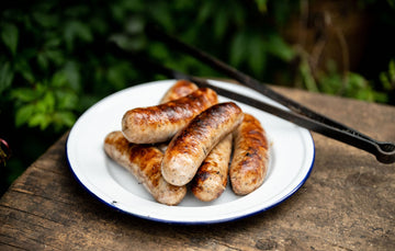 A plate of cooked Natural, free range, sage and onion turkey sausages.
