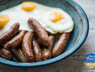 cooked native breed pork breakfast sausages with fried eggs