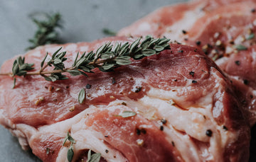 raw native breed pork steak with fresh thyme