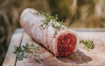 A raw and ready to cook Grass Fed Beef Sirloin with thyme.