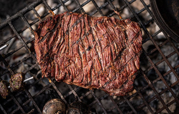 Grilled Grass Fed Bavette Steak cooking on a barbecue.