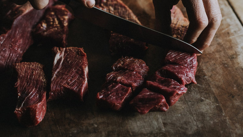 Raw Grass Fed Braising Beef being diced