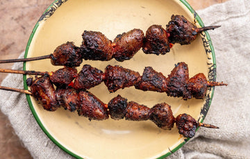 Barbecued properly free range chicken hearts on wooden skewers.