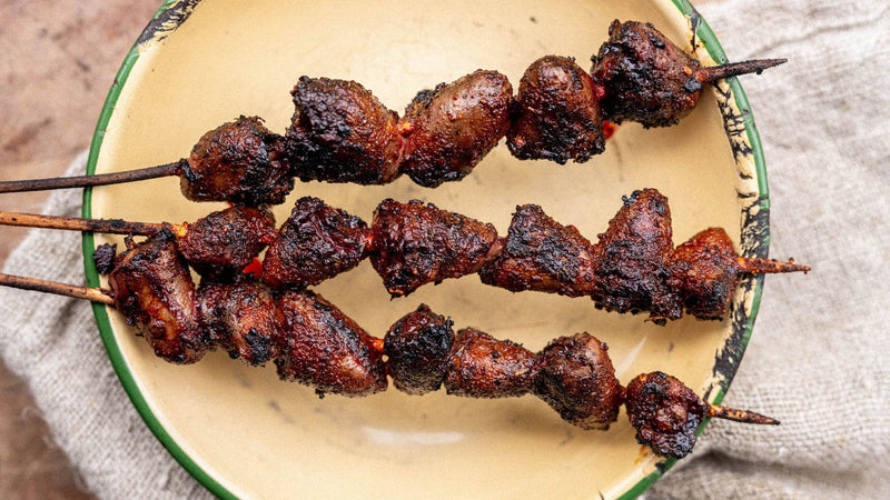Barbecued properly free range chicken hearts on wooden skewers.