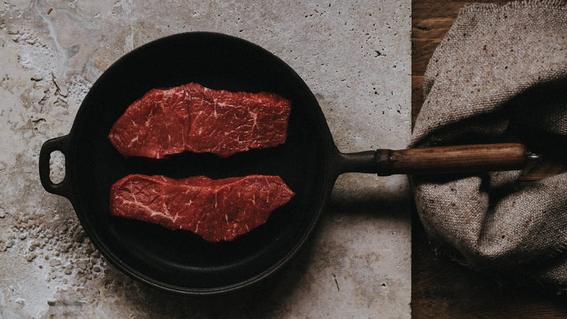 A pair of grass fed beef entrecote steaks in a frying pan.