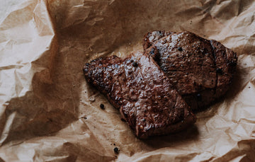 Two cooked grass fed beef everyday steaks with seasoning