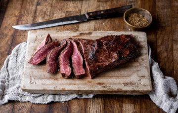 Cooked and sliced rare, grass fed beef flat iron steak