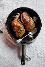 Cooked properly free range goose breasts with herbs and garlic in a pan