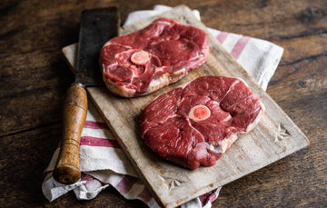 Raw grass fed lamb leg steaks on a chopping board.