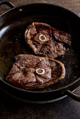 Grass fed lamb leg steaks cooking in a pan.
