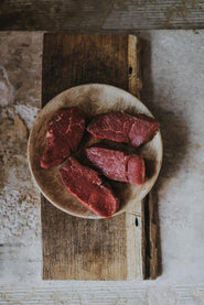 A plate of raw, grass fed lamb steaks.