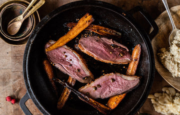 Cooked and sliced properly free range goose breast with carrots.