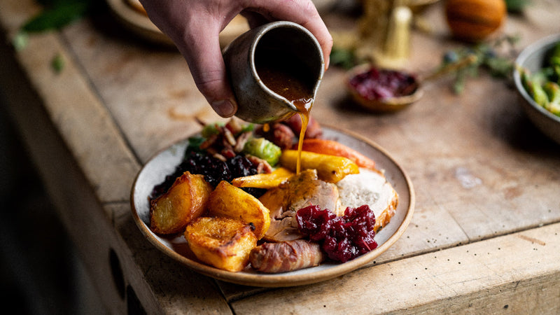 A full christmas roast dinner including turkey, potatoes, vegetables, and gravy