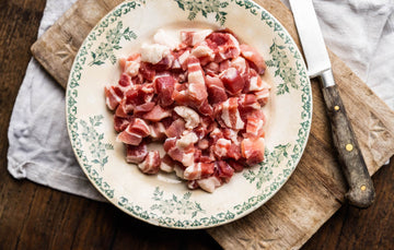 A plate of raw, Traditionally Cured Unsmoked Bacon Lardons.