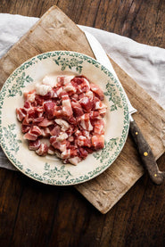 A plate of raw, Traditionally Cured Unsmoked Bacon Lardons.