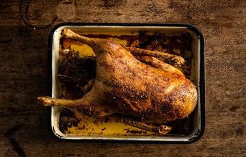 A cooked, whole properly free range goose with potatoes and gravy