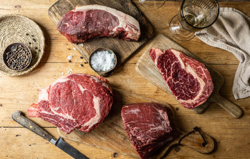 A selection of raw, grass fed, beef sirloin steaks with salt and pepper.