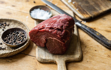 Large Grass-Fed Chateaubriand Steak on a wooden Board Showing Fine Marbling