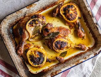 Cooked confit dug legs with sliced orange and bay leaves