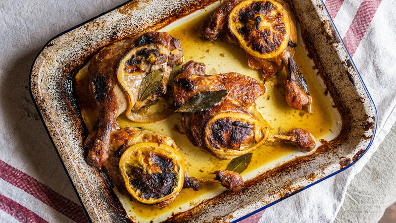 Cooked confit dug legs with sliced orange and bay leaves