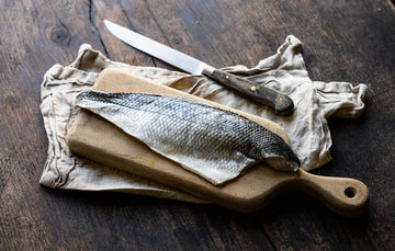 A British wild sea bass fillet on a chopping board.