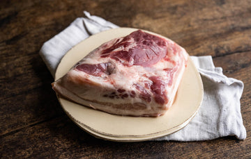 A raw native breed pigs cheek on a plate