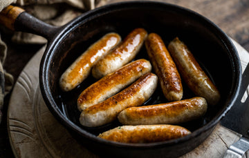 Golden-Brown Free-Range Chicken Sausages In A Pan, Perfectly Grilled For A Tasty.