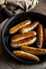 Cooked Free-Range Chicken Sausages In A Pan, Offering A Healthy And Lean Option For A Wholesome Meal.