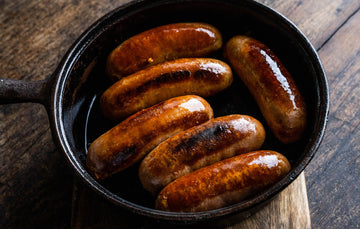 Cooked nashville chicken sausages in a pan.