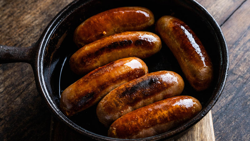 Cooked nashville chicken sausages in a pan.