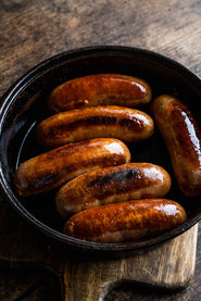 Cooked nashville chicken sausages in a pan.