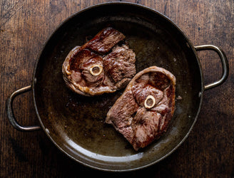 Grass fed lamb leg steaks cooking in a pan.