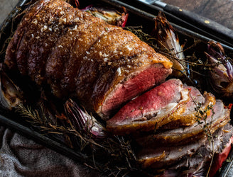 A cooked and sliced Grass Fed Beef Sirloin with onions and thyme.