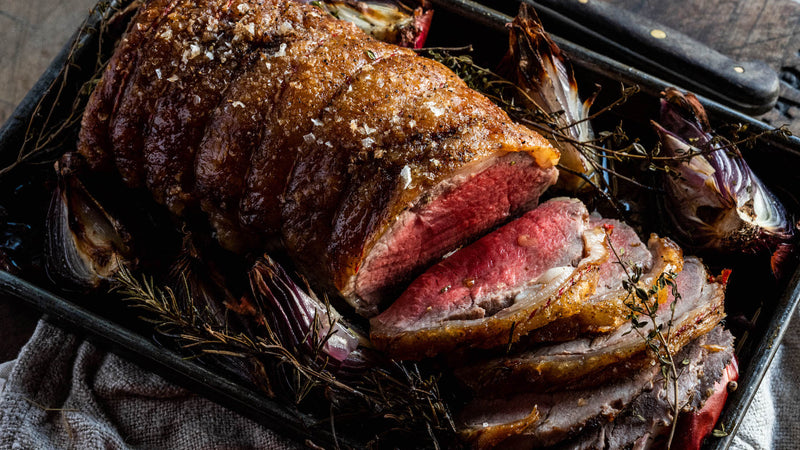 A cooked and sliced Grass Fed Beef Sirloin with onions and thyme.