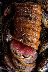 A cooked and sliced Grass Fed Beef Sirloin with onions and thyme.