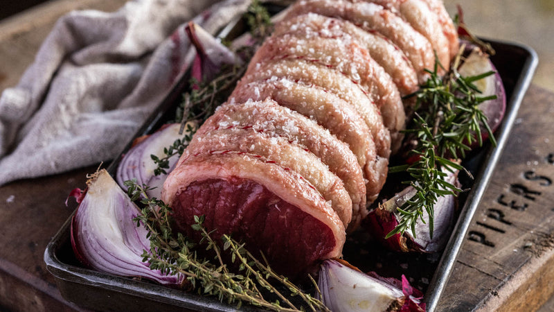 A raw and ready to cook Grass Fed Beef Sirloin with red onions and thyme.