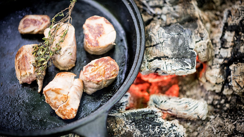 Native breed pork tenderloin cooking in a pan with fresh thyme