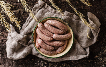 A bowl of raw, natural,native breed pork and apple sausages.