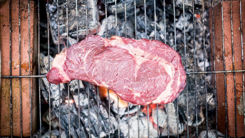 A Grass Fed Beef Ribeye Steak Cooking Over An Open Flame.