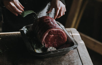 A Grass Fed, Rolled, Beef Brisket ready to cook, with herbs and garlic.
